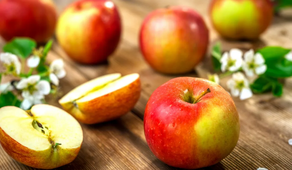 Raw organic apples on wooden background