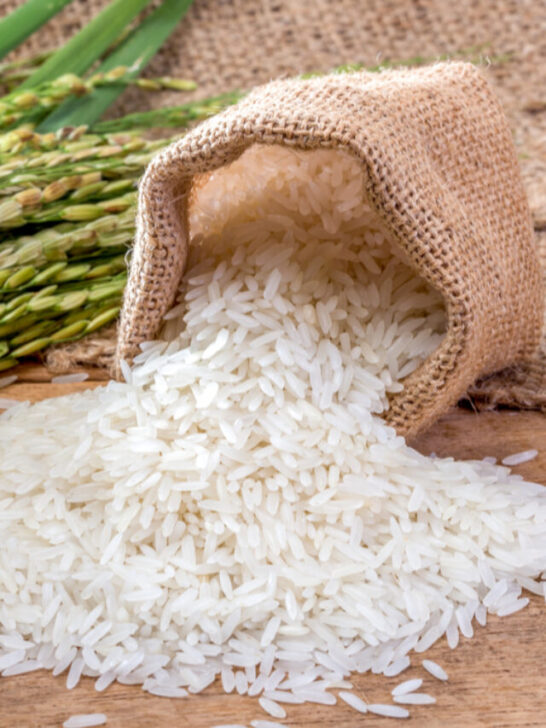 cropped-white-rice-brown-sack-green-leaf-wooden-table-ss220415.jpg