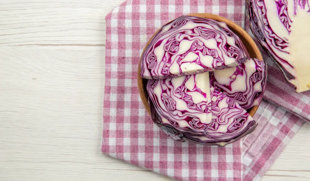 top view red cabbage in bowls purple and white checkered kitchen towel 