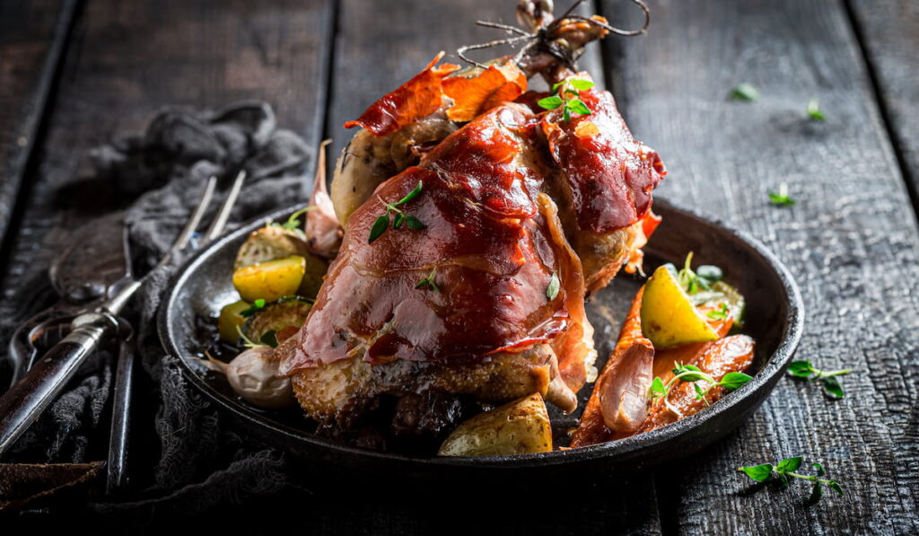 Tasty grilled pheasant with bacon, spices and vegetables