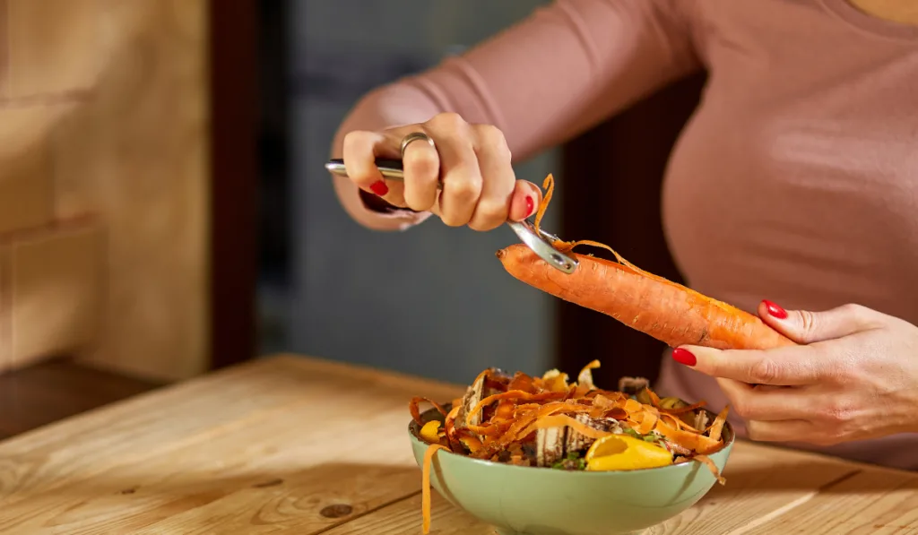 Women scraps peels carrots vegetable